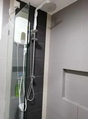 a shower in a bathroom with black and white tiles at Cozy Studio house /Soho Unit Near Kampar Utar in Kampar
