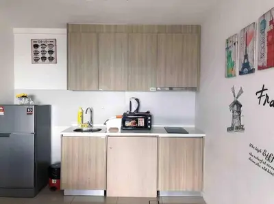 a kitchen with wooden cabinets and a refrigerator at Tropicana 218 Macalister Water Purifier High Floor in George Town