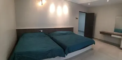 a bedroom with a bed with a green comforter at Orkid Apartment in Cameron Highlands