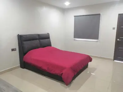 a bedroom with a black bed with a red blanket at Orkid Apartment in Cameron Highlands