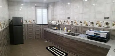 a kitchen with a sink and a counter with plates on the wall at Orkid Apartment in Cameron Highlands