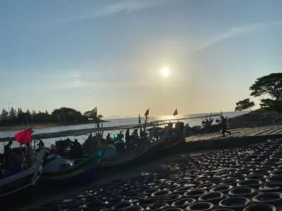 a group of people sitting in boats on the beach at An-Nur Homestay in Sungai Petani