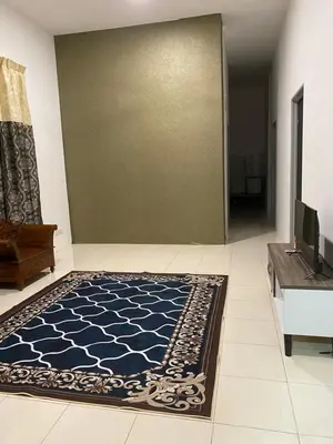 a living room with a blue and white rug at An-Nur Homestay in Sungai Petani