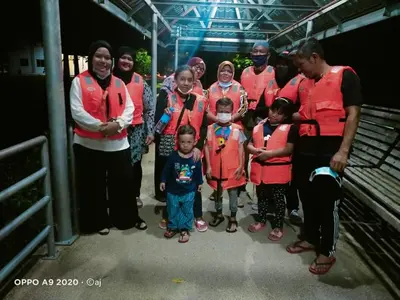 a group of people in red shirts posing for a picture at Izz Homestay Sawah Padi Sungai Besar ! in Kampong Parit Ten