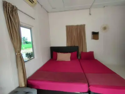 a large pink bed in a room with a window at Izz Homestay Sawah Padi Sungai Besar ! in Kampong Parit Ten
