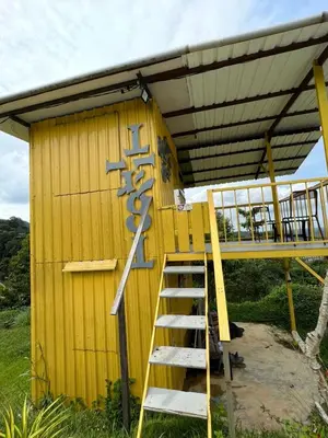 a ladder leading up to a yellow building with a roof at BUKIT LIMAU REST HOUSE in Taiping