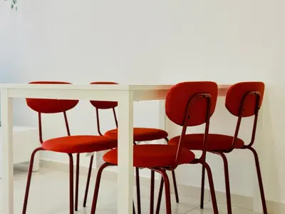 a white table with four red chairs around it at N New Georgetown Instagramable 2BR Homestay for 10pax \u65e0\u654c\u7f8e\u666f\u4e24\u623f\u6c11\u5bbf Beacon Executive Suite in George Town