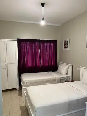 two beds in a room with a red window at Jarzmin Double Story Homestay @ Royal Lily in Tanah Rata