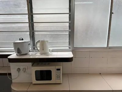 a kitchen with a microwave on a counter next to a window at Jarzmin Double Story Homestay @ Royal Lily in Tanah Rata