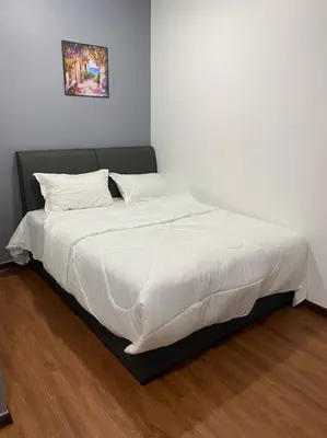 a bed with white sheets and pillows in a bedroom at Hi TechSTAY in Lunas