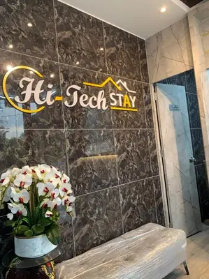 a bathroom with a sign on a tiled wall at Hi TechSTAY in Lunas