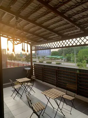 a patio with chairs and tables and a hotel sign at Hi TechSTAY in Lunas