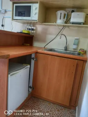 a kitchen with a sink and a microwave at Apartment Teluk Batik in Lumut