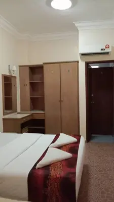 a room with a bed and some wooden cabinets at Apartment Teluk Batik in Lumut