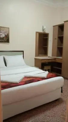 a bed with white sheets and pillows in a room at Apartment Teluk Batik in Lumut