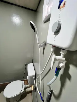 a hospital room with a toilet and a sink at Bertam Cottage Penang in Kepala Batas