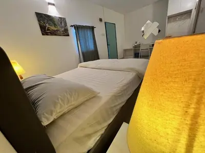 two twin beds in a room with a window at Bertam Cottage Penang in Kepala Batas