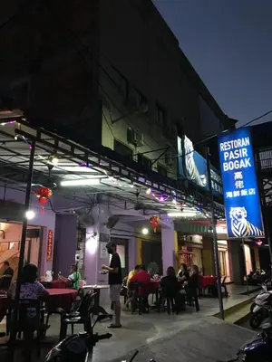 a man standing in front of a restaurant at night at Pangkor Coralbay Resort Room 208 apartment in Pangkor