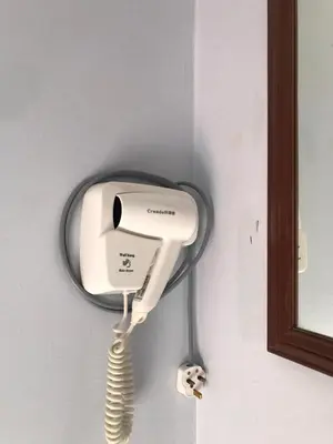 a white phone hanging on a wall next to a mirror at Pangkor Coralbay Resort Room 208 apartment in Pangkor