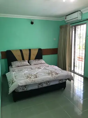a bedroom with a bed in a room with green walls at Suria Permai Homestay in Taiping