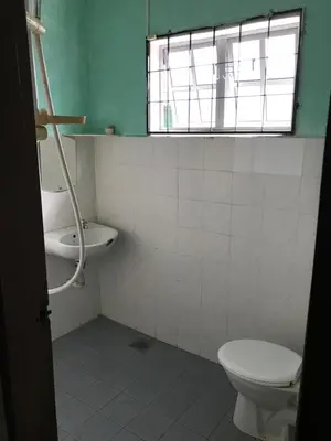 a bathroom with a toilet and a sink and a window at Suria Permai Homestay in Taiping