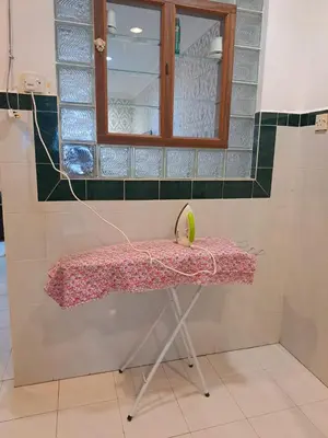 a table in a room with a window and a mirror at Suria Permai Homestay in Taiping
