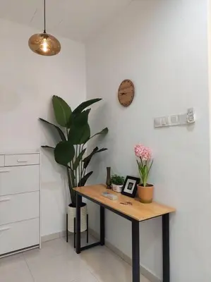 a room with a table with plants and a clock at Yong Guesthouse in Kuala Kangsar