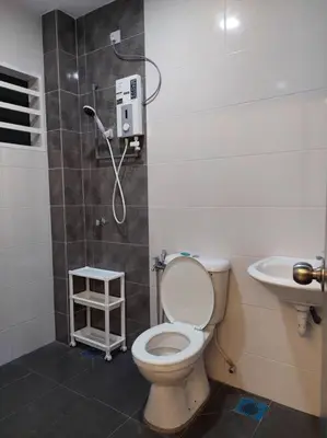 a bathroom with a shower and a toilet and a sink at Yong Guesthouse in Kuala Kangsar