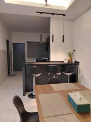 a kitchen with a table and chairs and a counter at Yong Guesthouse in Kuala Kangsar