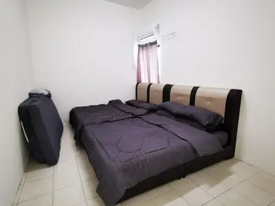 a bedroom with a bed and a suitcase at Happy homestay pulau pangkor in Kampong Sungai Udang