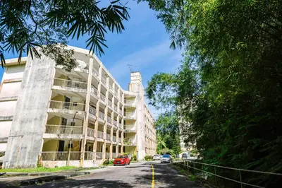 an apartment building on a street with cars parked at EE's Beach House - Homestay 3 min walk to beach in Batu Ferringhi