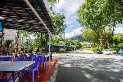 a group of tables with blue chairs on a street at EE's Beach House - Homestay 3 min walk to beach in Batu Ferringhi