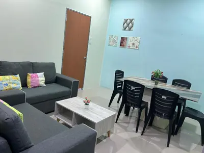 a living room with a couch and a table and chairs at Cyber Loft Homestay in Ipoh