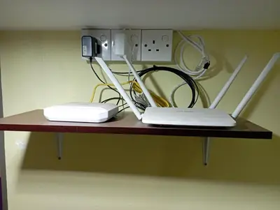 a table with a laptop and a phone on it at Evonne Budget Hotel in Tanah Rata