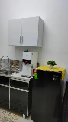 a kitchen with a small plant on top of a refrigerator at Embon Homestay in Padang Serai