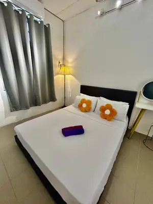 a bedroom with a white bed with flowers on it at Entire 33 Cozy House • 3 Bedroom @ Alma Bukit Mertajam in Bukit Mertajam