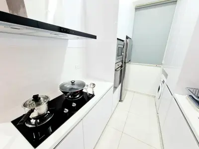 a white kitchen with two pots and pans on a stove at Beacon Executive Suites in George Town