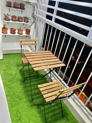 a table and chairs on a balcony with green grass at Ammar SkyHome Ipoh in Ipoh