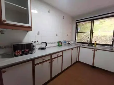 a kitchen with white cabinets and a sink and a microwave at Cozy Home Copthorne Equatorial Hill Resort in Brinchang
