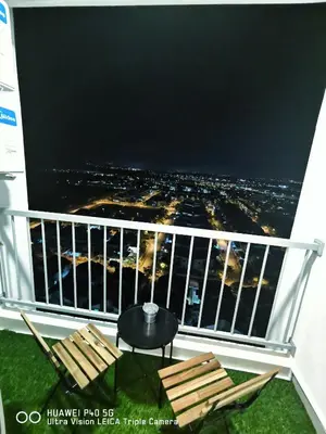 a balcony with two chairs and a table with a view at Adelea Homestay MERU in Ipoh
