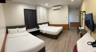a hotel room with two beds and a flat screen tv at T SQUARE HOTEL (IPOH) in Ipoh