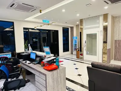 a man sitting at a desk in an office at T SQUARE HOTEL (IPOH) in Ipoh