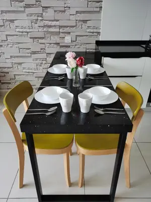 a black table with chairs and plates and flowers on it at ●T11●2Pax●Studio●5min●Queensbay●Pg Bridge View● in Bayan Lepas