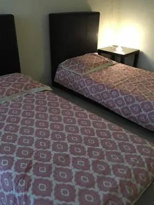 two beds sitting next to each other in a room at KS Lavender Kuala Kangsar in Kuala Kangsar