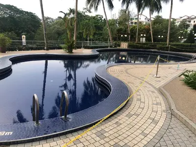 a swimming pool with a tiled path around it at Beach Resort Home Stay SRI SAYANG APARTMENT BATU FERRINGHI 2BEDROOM in Batu Ferringhi