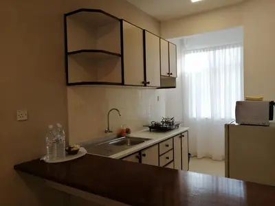 a kitchen with a sink and a refrigerator at Bayu Emas Apartment by Wellington Resorts in Batu Ferringhi