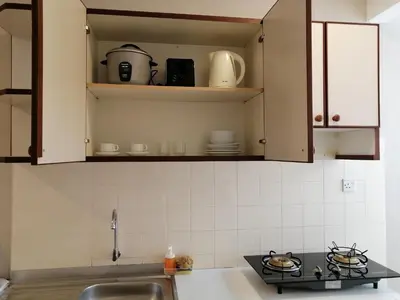 a kitchen with a sink and a counter top at Bayu Emas Apartment by Wellington Resorts in Batu Ferringhi
