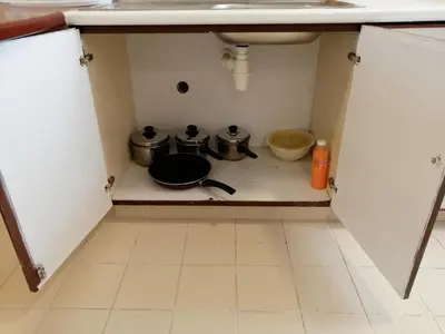 a kitchen with two pots and pans on a stove at Bayu Emas Apartment by Wellington Resorts in Batu Ferringhi