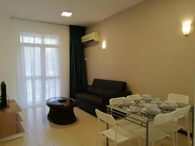 a living room with a table and a couch at Bayu Emas Apartment by Wellington Resorts in Batu Ferringhi