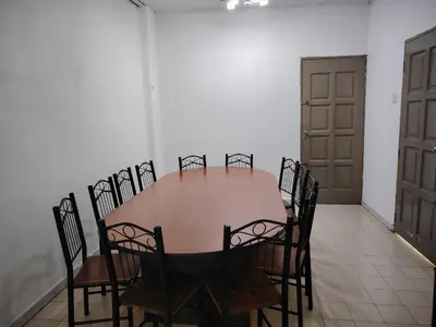 a dining room with a table and chairs and a door at Prairie Villa Homestay in Lumut